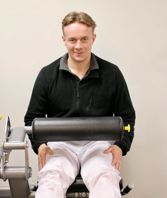 Medarbetaren David som är fysioterapeut sitter i en av gymmets träningsmaskiner