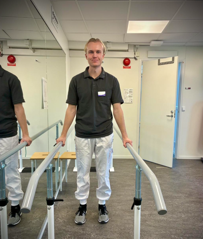 Medarbetaren Gabriel står i en balansbom i gymmet på rehabavdelningen