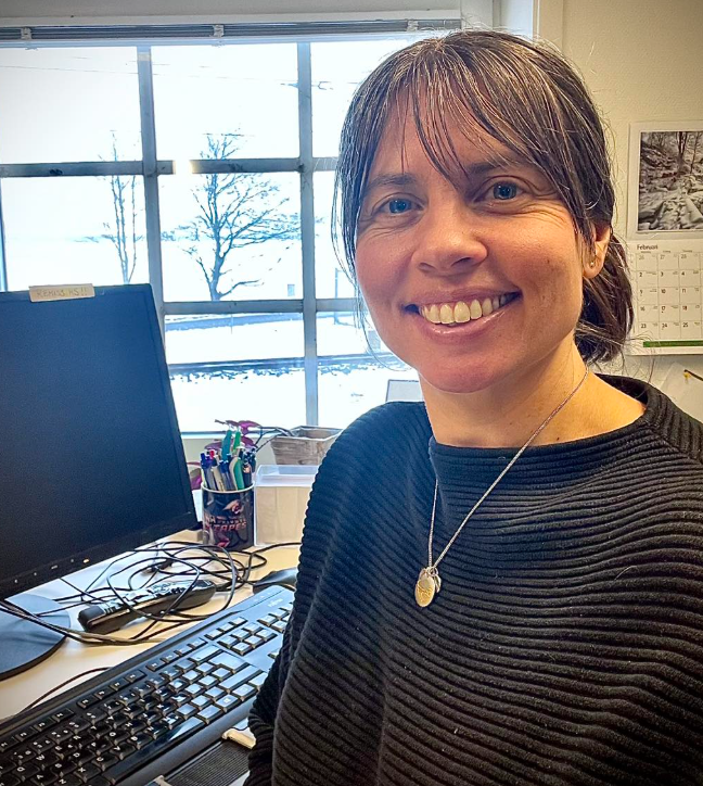 Vårdsamordnare Nina sitter vid sitt skrivbord och har datorn intill sig.