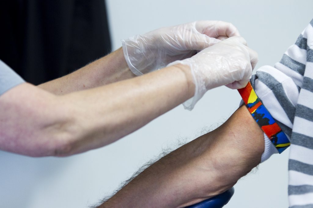 Händer med skyddshandskar förbereder patient för vaccination