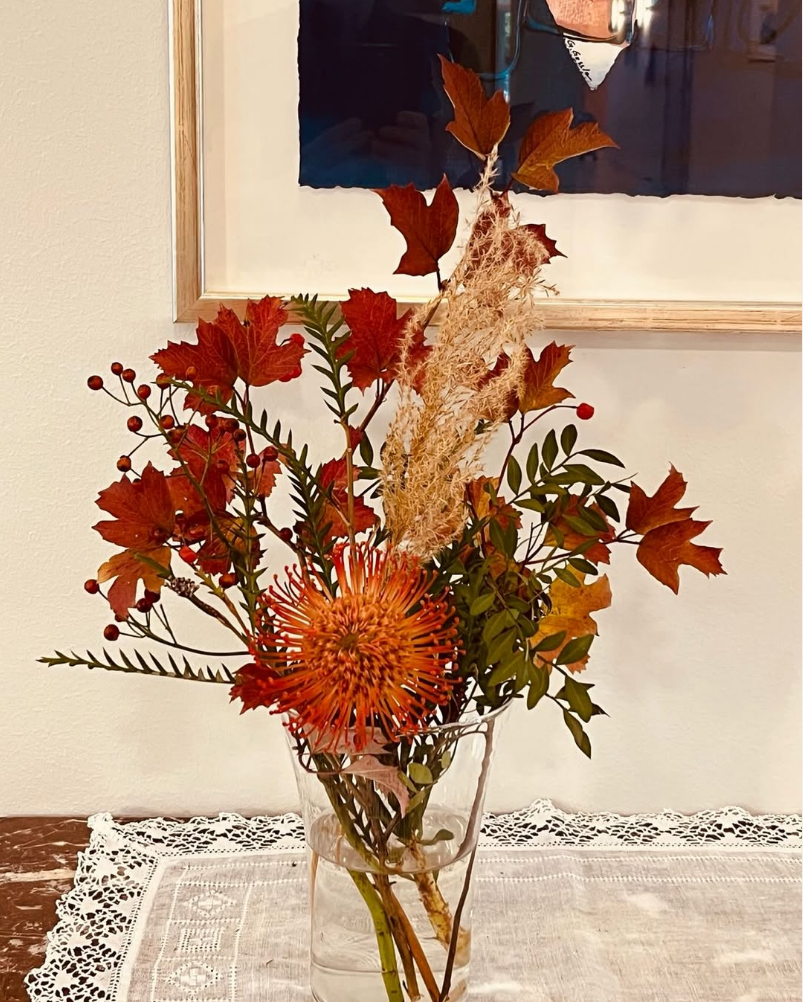 Bukett med höstlika blommor på ett bort